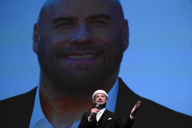 US director, screenwriter and writer John Travolta receives an honourary lifetime achievement Palm d'Or award prior to the screening of the film "Propeller One-Way Night Coach" at the 79th edition of the Cannes Film Festival in Cannes, southern France on May 15, 2026. (Photo by Olivier CHASSIGNOLE / AFP)