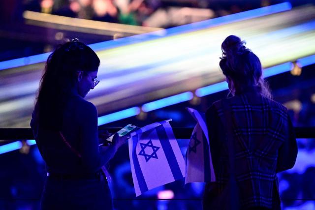 Fans hold Israeli flags prior to the start of the dress rehearsal for the grand final of the Eurovision Song Contest 2026 (ESC) at Wiener Stadthalle in Vienna, Austria on May 15, 2026. (Photo by Tobias SCHWARZ / AFP)