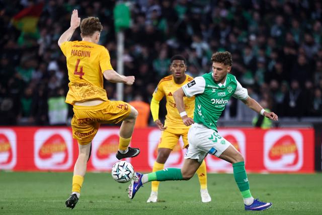 Rodez's Swiss defender #04 Mathis Magnin (L) fights for the ball with Saint-Etienne's Belgian forward #09 Lucas Stassin (R) during the French L1-L2 playoff second leg football match between AS Saint-Etienne and Rodez at the stade Geoffroy Guichard in Saint-Etienne, south-eastern France on May 15, 2026. (Photo by Alex MARTIN / AFP)