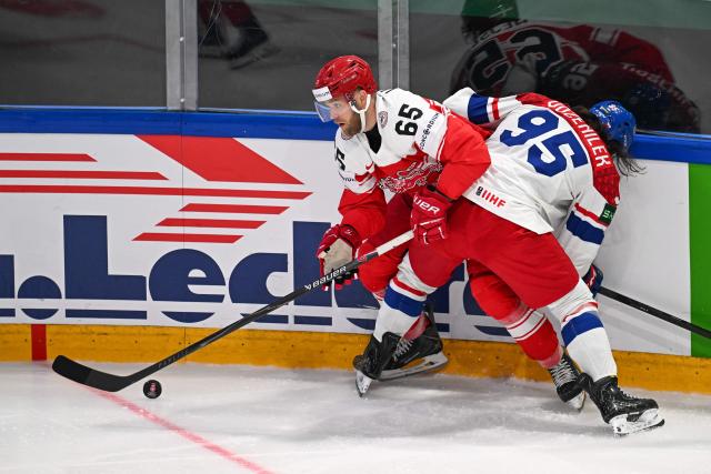 Czech Republic's defender #65 Tomas Cibulka (L) and Czech Republic's forward #95 Daniel Vozenilek (R) fight for the puck during the group B match between Czech Republic and Denmark at the IIHF Ice Hockey Men's World Championship in the BFC Arena, Fribourg, on May 15, 2026. (Photo by Fabrice COFFRINI / AFP)