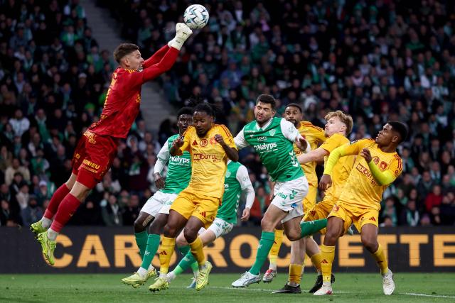 Rodez's French goalkeeper #01 Quentin Braat (L) boxes the ball in front of Saint-Etienne's French defender #26 Julien Le Cardinal (C) during the French L1-L2 playoff second leg football match between AS Saint-Etienne and Rodez at the stade Geoffroy Guichard in Saint-Etienne, south-eastern France on May 15, 2026. (Photo by Alex MARTIN / AFP)