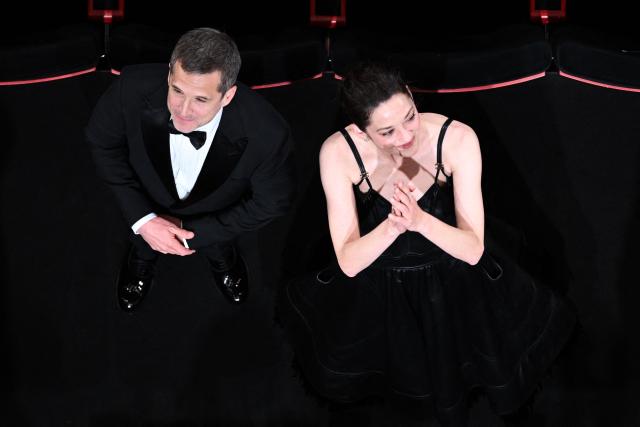 French director and screenwriter Guillaume Canet (L) and French actress Marion Cotillard acknowledge the audiences after the screening of the film "Karma" at the 79th edition of the Cannes Film Festival in Cannes, southern France on May 15, 2026. (Photo by Antonin THUILLIER / AFP)