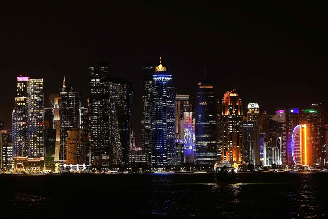 Illuminated skyscrapers are pictured along the corniche promenade in Doha on May 15, 2026. (Photo by Karim JAAFAR / AFP)