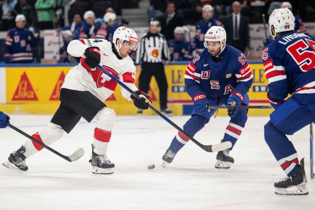 Switzerland's forward #44 Pius Suter (L) fights for the puck against USA's forward #63 Max Sasson (R) during the IIHF Ice Hockey Men's World Championship first round group A ice hockey match between USA and Switzerland at the Swiss Life Arena, in Zurich, on May 15, 2026. (Photo by ENNIO LEANZA / AFP)