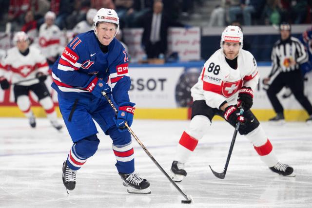 USA's forward #11 Oliver Moore (L) fights for the puck against Switzerland's forward #88 Christoph Bertschy (R) during the IIHF Ice Hockey Men's World Championship first round group A ice hockey match between USA and Switzerland at the Swiss Life Arena, in Zurich, on May 15, 2026. (Photo by ENNIO LEANZA / AFP)