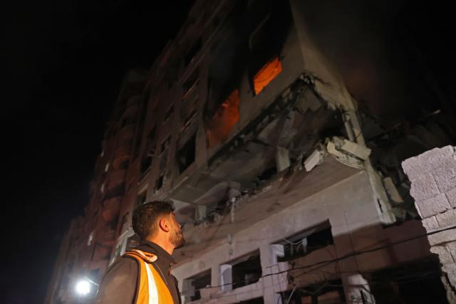 A first responder looks at the fire in a residential building after an Israeli strike in the Rimal neighbourhood of Gaza City on May 15, 2026. Israel said on May 15 that it carried out a strike in Gaza targeting Ezzedine Al-Haddad, who it described as chief of the armed wing of Palestinian movement Hamas. Since Hamas's October 7, 2023 attack on Israel, the Israeli military and intelligence services have waged an extensive campaign targeting the group's senior political leaders and militant commanders in Gaza and across the region. (Photo by Omar AL-QATTAA / AFP)