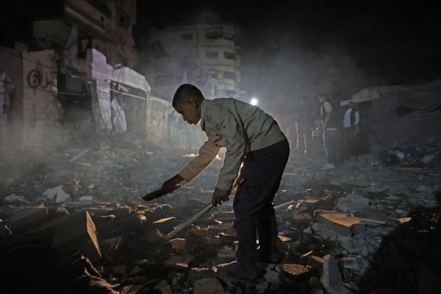 A Palestinian boy inspects the site of an Israeli strike in the Rimal neighbourhood of Gaza City on May 15, 2026. Israel said on May 15 that it carried out a strike in Gaza targeting Ezzedine Al-Haddad, who it described as chief of the armed wing of Palestinian movement Hamas. Since Hamas's October 7, 2023 attack on Israel, the Israeli military and intelligence services have waged an extensive campaign targeting the group's senior political leaders and militant commanders in Gaza and across the region. (Photo by Omar AL-QATTAA / AFP)