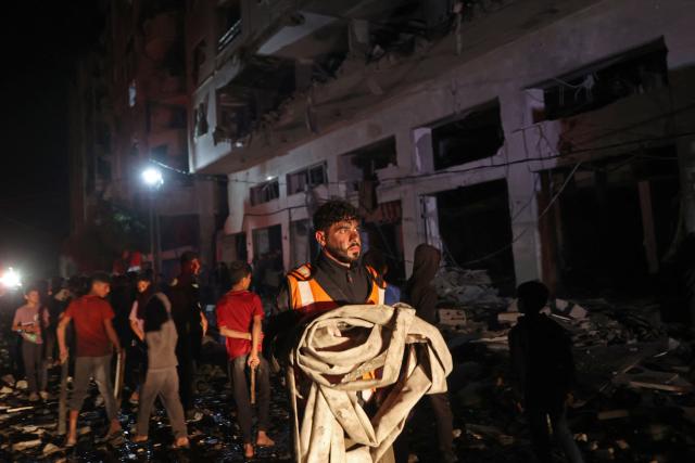 A first responder carries a waterpipe at the site of an Israeli strike in the Rimal neighbourhood of Gaza City on May 15, 2026. Israel said on May 15 that it carried out a strike in Gaza targeting Ezzedine Al-Haddad, who it described as chief of the armed wing of Palestinian movement Hamas. Since Hamas's October 7, 2023 attack on Israel, the Israeli military and intelligence services have waged an extensive campaign targeting the group's senior political leaders and militant commanders in Gaza and across the region. (Photo by Omar AL-QATTAA / AFP)