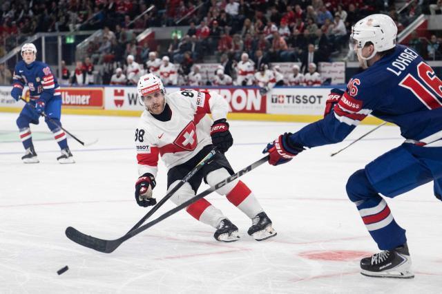 Switzerland's forward #88 Christoph Bertschy (L) fights for the puck with USA's defender #16 Mason Lohrei (R) during the IIHF Ice Hockey Men's World Championship first round group A ice hockey match between USA and Switzerland at the Swiss Life Arena, in Zurich, on May 15, 2026. (Photo by ENNIO LEANZA / AFP)
