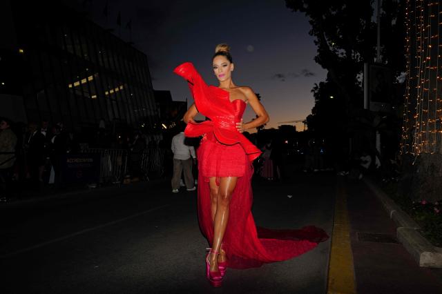A festival-goer in evening attire walks along the Boulevard de la Croisette near the Palais des Festivals on the sidelines of the 79th edition of the Cannes Film Festival in Cannes, southern France on May 15, 2026. (Photo by VALERY HACHE / AFP)
