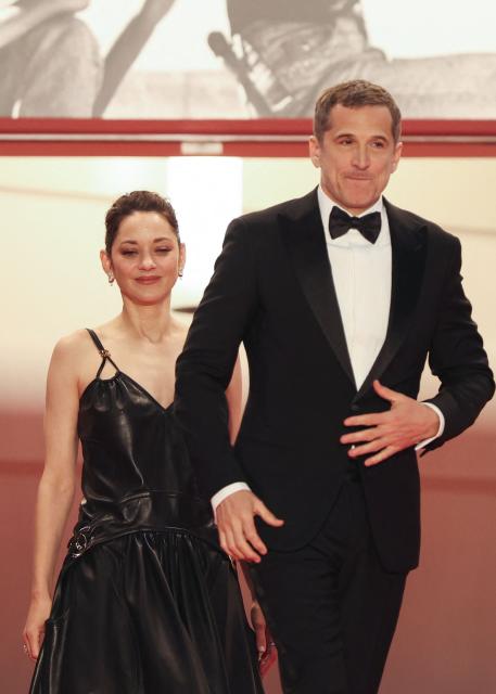 French actress Marion Cotillard and French director and screenwriter Guillaume Canet leave after the screening of the film "Karma" at the 79th edition of the Cannes Film Festival in Cannes, southern France on May 15, 2026. (Photo by Sameer AL-DOUMY / AFP)