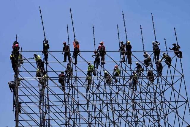 Workers set up scaffolding for the assembly of giant screens and stages of the FIFA Fan Festival at Zocalo square ahead of the World Cup in Mexico City on May 15, 2026. Mexico will co-host the biggest World Cup in history along with the United States and Canada from June 11 to July 19, 2026. (Photo by Yuri CORTEZ / AFP)