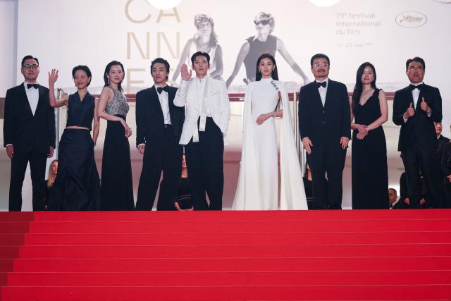 (From 2L) South Korean actor Kim Shin-Rock, South Korean actress Shin Hyeon-Been, South Korean actor Koo Kyo-Hwan, South Korean actor Ji Chang-Wook, South Korean actress Jun Ji-Hyun, South Korean director Yeon Sang-Ho, South Korean producer Hailey Yoomin Yang arrive for the screening of the film "Gun-Che" (Colony) at the 79th edition of the Cannes Film Festival in Cannes, southern France on May 15, 2026. (Photo by Sameer AL-DOUMY / AFP)