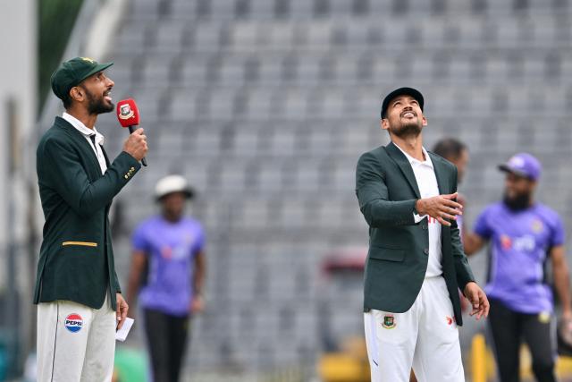 Bangladesh's captain Najmul Hossain Shanto (R) tosses a coin as Pakistan's captain Shan Masood (L) looks on before the start of play on the first day of the second Test cricket match between Bangladesh and Pakistan at Sylhet International Cricket Stadium in Sylhet on May 16, 2026. (Photo by MUNIR UZ ZAMAN / AFP)
