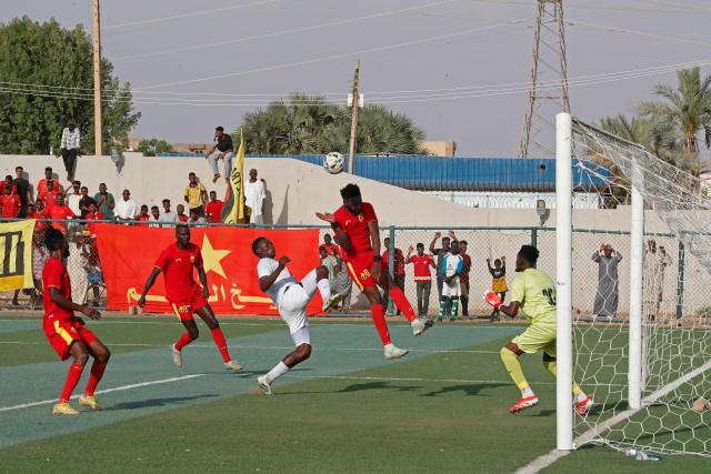 Al Merrikh's players (in red) fight for the ball with player from Ahli Madani during the Sudanese Premier League's opening football match between Al Merrikh and Ahli Madani at the Kober Stadium in Khartoum North, on May 15, 2026. Football returned to Sudan's war-scarred capital on May 15 as the domestic league staged its first matches since the conflict began at battered stadiums on the edges of a largely abandoned Khartoum. (Photo by Ebrahim Hamid / AFP)
