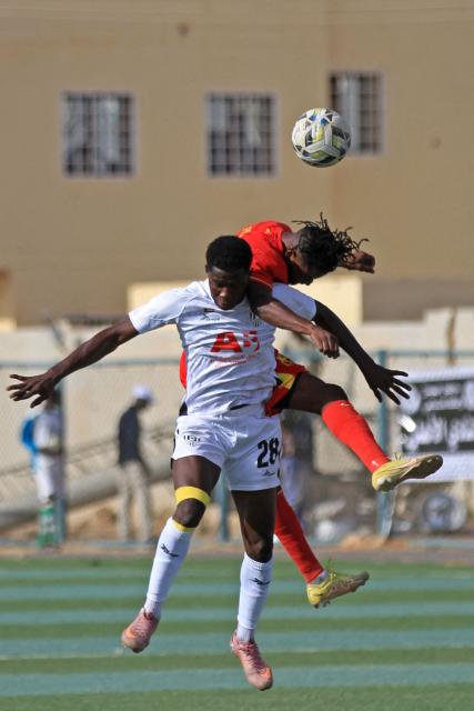 Al Merrikh's player (in red) heads the ball past player from Ahli Madani during the Sudanese Premier League's opening football match between Al Merrikh and Ahli Madani at the Kober Stadium in Khartoum North, on May 15, 2026. Football returned to Sudan's war-scarred capital on May 15 as the domestic league staged its first matches since the conflict began at battered stadiums on the edges of a largely abandoned Khartoum. (Photo by Ebrahim Hamid / AFP)