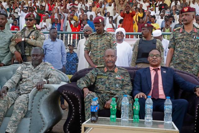 Sudan's de facto leader and army chief Abdel Fattah al-Burhan (C) attends the Sudanese Premier League's opening football match between Al Merrikh and Ahli Madani at the Kober Stadium in Khartoum North, on May 15, 2026. Football returned to Sudan's war-scarred capital on May 15 as the domestic league staged its first matches since the conflict began at battered stadiums on the edges of a largely abandoned Khartoum. (Photo by Ebrahim Hamid / AFP)