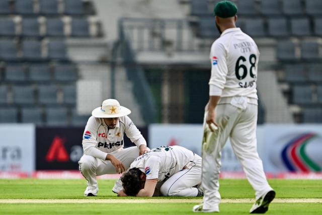 Pakistan’s Hasan Ali (C) reacts upon suffering an injury as Azan Awais consoles during the first day of the second Test cricket match between Bangladesh and Pakistan at the Sylhet International Cricket Stadium in Sylhet on May 16, 2026. (Photo by Munir UZ ZAMAN / AFP)