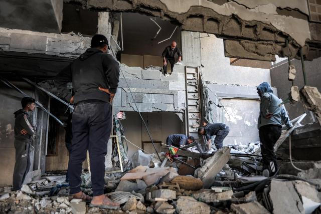 People inspect the aftermath of an Israeli strike from the previous day on residential building in the Rimal neighbourhood of Gaza City on May 16, 2026. Israel said on May 15 that it carried out a strike in Gaza targeting Ezzedine Al-Haddad, who described it as chief of the armed wing of Palestinian movement Hamas. Since Hamas's October 7, 2023 attack on Israel, the Israeli military and intelligence services have waged an extensive campaign targeting the group's senior political leaders and militant commanders in Gaza and across the region. (Photo by Omar AL-QATTAA / AFP)