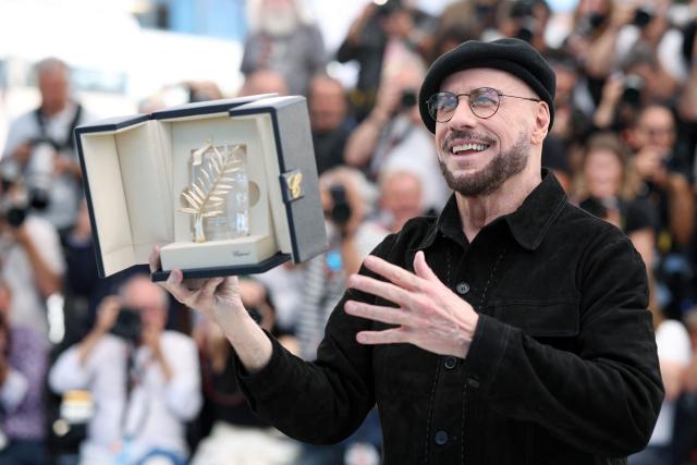 US director, screenwriter and writer John Travolta poses with an honourary lifetime achievement Palm d'Or award during a photocall of the film "Vol de nuit pour Los Angeles" (Propeller One-Way Night Coach) at the 79th edition of the Cannes Film Festival in Cannes, southern France on May 16, 2026. (Photo by Valery HACHE / AFP)