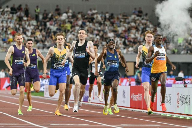 Ireland's Mark English (C) crosses the finish line to win the men's 800m event and break the meeting's record during the Shanghai/Keqiao Diamond League athletics meeting in Keqiao, Shaoxing in China's eastern Zhejiang province on May 16, 2026. (Photo by HECTOR RETAMAL / AFP)