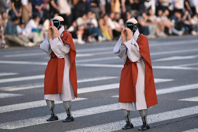 Humanoid robots dressed as Buddhist monks attend at a parade as part of a 'Lotus Lantern Festival' to celebrate the upcoming Buddha's birthday, in Seoul on May 16, 2026. (Photo by Jung Yeon-je / AFP)