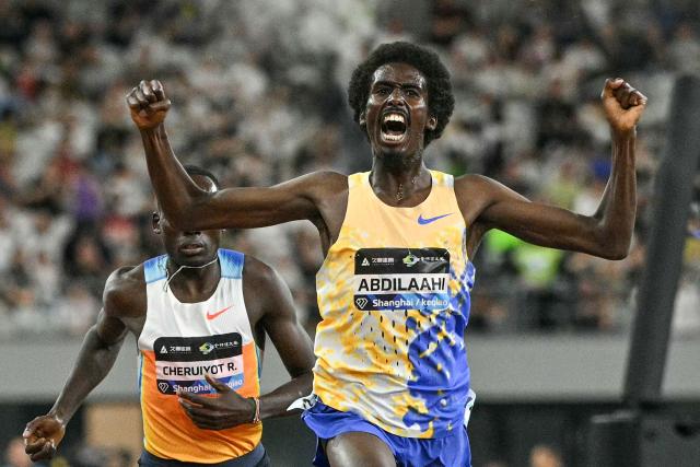 Germany's Mohamed Abdilaahi (R) celebrates winning the men's 3000m event during the Shanghai/Keqiao Diamond League athletics meeting in Keqiao, Shaoxing in China's eastern Zhejiang province on May 16, 2026. (Photo by HECTOR RETAMAL / AFP)