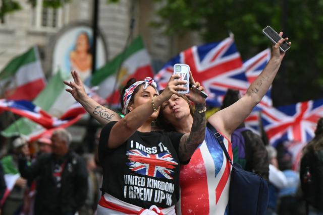 Supporters of British far-right activist Tommy Robinson, real name Stephen Yaxley-Lennon, take a selfie photo as they take part in a march organised by Unite The Kingdom, in central London on May 16, 2026. (Photo by JUSTIN TALLIS / AFP)