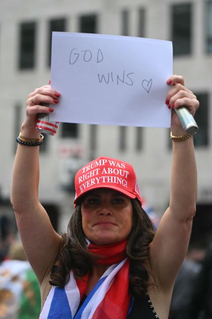 A supporter of British far-right activist Tommy Robinson, real name Stephen Yaxley-Lennon, shows a message during a march organised by Unite The Kingdom, in central London on May 16, 2026. (Photo by JUSTIN TALLIS / AFP)