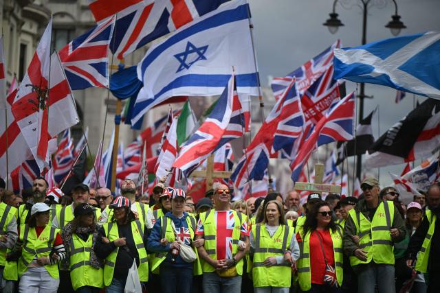 Stewards link arms as supporters of British far-right activist Tommy Robinson, real name Stephen Yaxley-Lennon, take part in a march organised by Unite The Kingdom, in central London on May 16, 2026. (Photo by JUSTIN TALLIS / AFP)