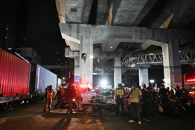 Police officers and rescue workers are seen at the site of a train collision with a bus underneath Makkasan Airport Rail station in Bangkok on May 16, 2026. A collision between a freight train and a bus killed at least eight people and injured more than 30 in the Thai capital Bangkok, emergency services said. (Photo by Lillian SUWANRUMPHA / AFP)
