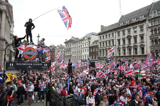 TOPSHOT - On Whitehall, supporters of British far-right activist Tommy Robinson, real name Stephen Yaxley-Lennon, take part in a march organised by Unite The Kingdom, in central London on May 16, 2026. (Photo by Toby Shepheard / AFP)