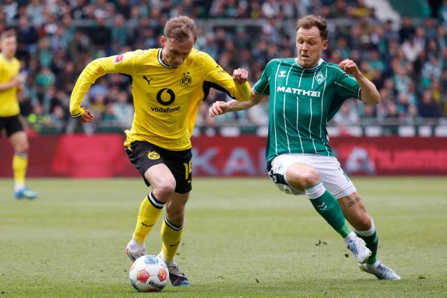 Dortmund's German forward #14 Maximilian Beier and Bremen's Belgian midfielder #14 Senne Lynen vie for the ball during the German first division Bundesliga football match between Werder Bremen and Borussia Dortmund in Bremen, northwestern Germany, on May 16, 2026. (Photo by Focke Strangmann / AFP) / DFL REGULATIONS PROHIBIT ANY USE OF PHOTOGRAPHS AS IMAGE SEQUENCES AND/OR QUASI-VIDEO