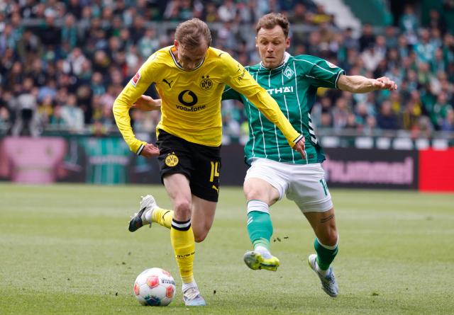 Dortmund's German forward #14 Maximilian Beier and Bremen's Belgian midfielder #14 Senne Lynen vie for the ball during the German first division Bundesliga football match between Werder Bremen and Borussia Dortmund in Bremen, northwestern Germany, on May 16, 2026. (Photo by Focke Strangmann / AFP) / DFL REGULATIONS PROHIBIT ANY USE OF PHOTOGRAPHS AS IMAGE SEQUENCES AND/OR QUASI-VIDEO