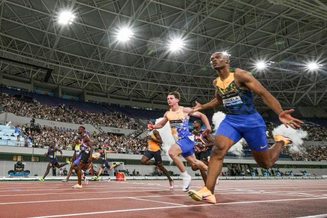 South Africa's Gift Leotlela (R) wins the men's 100m event during the Shanghai/Keqiao Diamond League athletics meeting in Keqiao, Shaoxing in China's eastern Zhejiang province on May 16, 2026. (Photo by Hector RETAMAL / AFP)