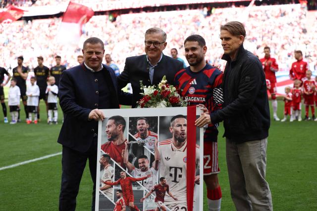 Bayern Munich's Portuguese defender #22 Raphael Guerreiro (2nd R) celebrates his departure near Bayern Munich's Austrian sporting director Christoph Freund (R), FC Bayern Munich's German CEO Jan-Christian Dreesen (2nd L) and Bayern Munich's sporting CEO Max Eberl (L) prior to the start of the German first division Bundesliga football match between FC Bayern Munich and FC Cologne in Munich, southern Germany, on May 16, 2026. (Photo by Alexandra BEIER / AFP) / DFL REGULATIONS PROHIBIT ANY USE OF PHOTOGRAPHS AS IMAGE SEQUENCES AND/OR QUASI-VIDEO