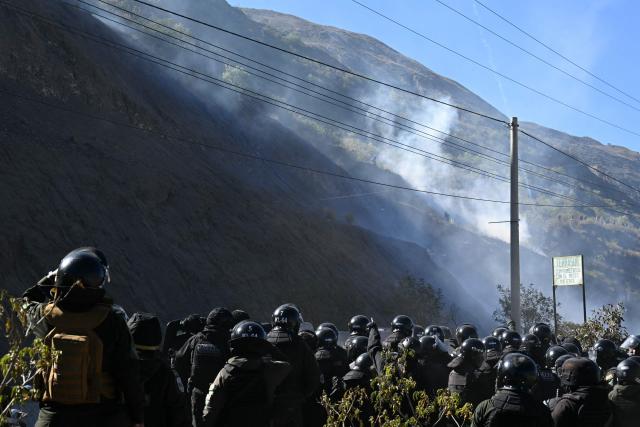 Riot police officers stand amid tear gas during clashes with rural protesters in Lipari, La Paz department, Bolivia, on May 16, 2026. Bolivia's government reached an agreement on May 15 with thousands of miners who clashed with police in a protest that paralysed downtown La Paz. However, other sectors continue to block access routes to the city, home to the executive branch and Congress. (Photo by AIZAR RALDES / AFP)