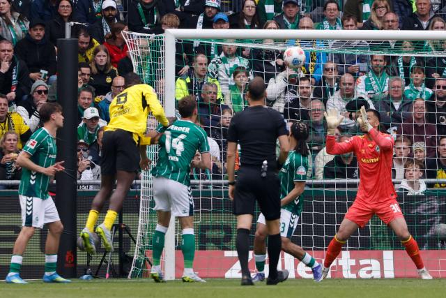 Bremen's German goalkeeper #30 Mio Backhaus saves the ball headed by Dortmund's Guinean forward #09 Serhou Guirassy during the German first division Bundesliga football match between Werder Bremen and Borussia Dortmund in Bremen, northwestern Germany, on May 16, 2026. (Photo by Focke Strangmann / AFP) / DFL REGULATIONS PROHIBIT ANY USE OF PHOTOGRAPHS AS IMAGE SEQUENCES AND/OR QUASI-VIDEO