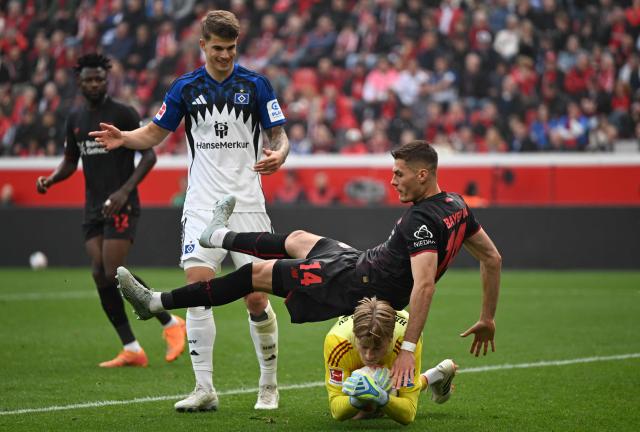 Hamburg's Norwegian goalkeeper #12 Sander Tangvik saves the ball against Bayer Leverkusen's Czech forward #14 Patrik Schick during the German first division Bundesliga football match between Bayer Leverkusen and Hamburger SV (HSV) in Leverkusen, western Germany, on May 16, 2026. (Photo by INA FASSBENDER / AFP) / DFL REGULATIONS PROHIBIT ANY USE OF PHOTOGRAPHS AS IMAGE SEQUENCES AND/OR QUASI-VIDEO