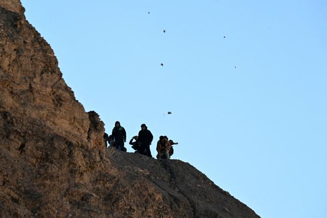 Rural protesters throw stones at riot police from a hillside during clashes in Lipari, La Paz department, Bolivia, on May 16, 2026. Bolivia's government reached an agreement on May 15 with thousands of miners who clashed with police in a protest that paralysed downtown La Paz. However, other sectors continue to block access routes to the city, home to the executive branch and Congress. (Photo by AIZAR RALDES / AFP)