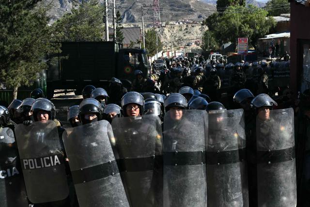 Riot police officers stand guard during clashes with rural protesters in Lipari, La Paz department, Bolivia, on May 16, 2026. Bolivia's government reached an agreement on May 15 with thousands of miners who clashed with police in a protest that paralysed downtown La Paz. However, other sectors continue to block access routes to the city, home to the executive branch and Congress. (Photo by AIZAR RALDES / AFP)