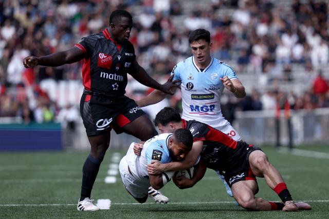 Lyon's French wing Ethan Dumortier (C-R) tackles Bayonne’s French full-back Cheikh Tiberghien (C-L)during the French Top14 rugby union match between Lyon Olympique Universitaire Rugby and Aviron Bayonnais (Bayonne) at the Gerland Stadium in Lyon, central-eastern France on May 16, 2026. (Photo by Alex MARTIN / AFP)