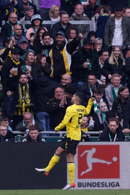 Dortmund's Brazilian defender #02 Yan Couto celebrates after scoring his team's second goal 0:2 during the German first division Bundesliga football match between Werder Bremen and Borussia Dortmund in Bremen, northwestern Germany, on May 16, 2026. (Photo by Focke Strangmann / AFP) / DFL REGULATIONS PROHIBIT ANY USE OF PHOTOGRAPHS AS IMAGE SEQUENCES AND/OR QUASI-VIDEO