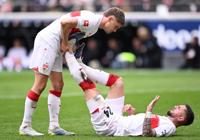 Stuttgart's Dutch defender #03 Ramon Hendriks (L) helps Stuttgart's German defender #24 Jeff Chabot during the German first division Bundesliga football match between Eintracht Frankfurt and VfB Stuttgart in Frankfurt am Main, western Germany, on May 16, 2026. (Photo by Kirill KUDRYAVTSEV / AFP) / DFL REGULATIONS PROHIBIT ANY USE OF PHOTOGRAPHS AS IMAGE SEQUENCES AND/OR QUASI-VIDEO