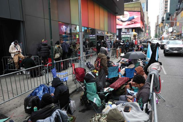 This photo taken on May 15, 2026, shows people camping out in line outside of the Swatch store in Times Square in New York, ahead of the May 16 release of the Audemars Piguet x Swatch Royal Pop watch. The collaboration between two Swiss watch brands, Swatch and Audemars Piguet, was highly anticipated by fans with some clients waiting for days ahead of the release. (Photo by TIMOTHY A. CLARY / AFP)