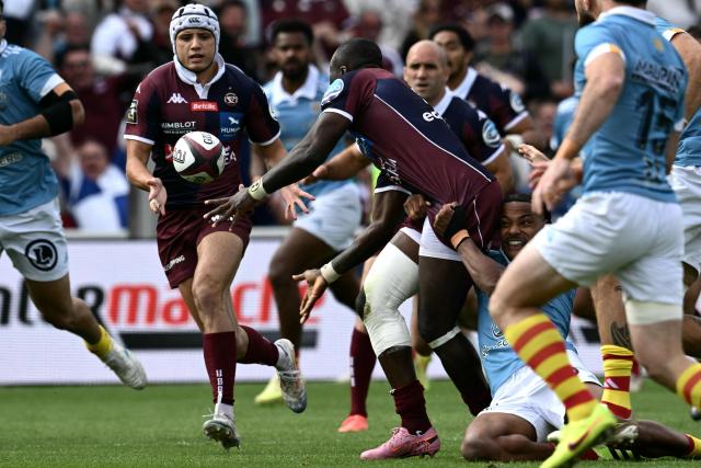 Bordeaux-Begles' South African winger Madosh Tambwe (C) passes the ball to Bordeaux-Begles' French full-back Louis Bielle-Biarrey (L) during the French Top 14 rugby union match between Union Bordeaux-Begles (UBB) and USAP Perpignan at the Chaban-Delmas Stadium in Bordeaux, south-western France on May 16, 2026. (Photo by Philippe LOPEZ / AFP)