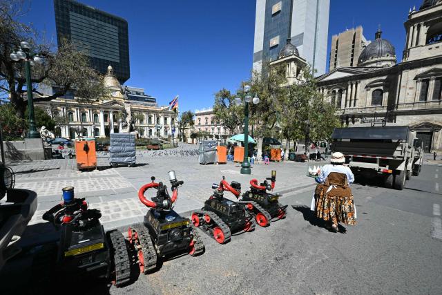 Remote-controlled robots and armoured vehicles for riot control are deployed in Plaza Murillo near government buildings in La Paz on May 16, 2026. Bolivia's government reached an agreement on May 15 with thousands of miners who clashed with police in a protest that paralysed downtown La Paz. However, other sectors continue to block access routes to the city, home to the executive branch and Congress. (Photo by AIZAR RALDES / AFP)