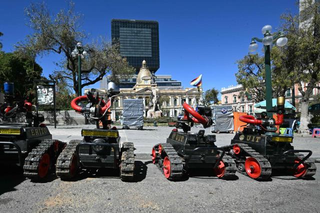 Remote-controlled riot-control robots are deployed in Plaza Murillo near government buildings in La Paz on May 16, 2026. Bolivia's government reached an agreement on May 15 with thousands of miners who clashed with police in a protest that paralysed downtown La Paz. However, other sectors continue to block access routes to the city, home to the executive branch and Congress. (Photo by AIZAR RALDES / AFP)