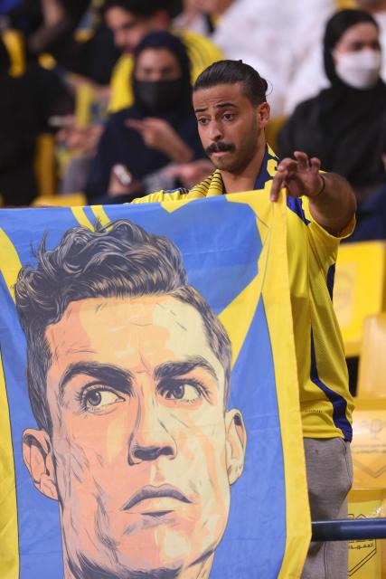 A fan holds a banner with picture of Nassr's Portuguese forward #07 Cristiano Ronaldo before the start of the 2026 AFC Champions League Two final football match between Al-Nassr and Gamba Osaka at the Al-Awwal Park Stadium in Riyadh on May 16, 2026. (Photo by Fayez NURELDINE / AFP)
