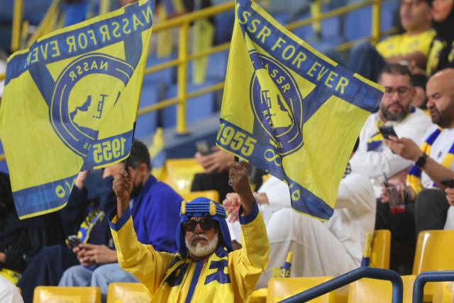 A Nassr's team fan waves flags before the start of the 2026 AFC Champions League Two final football match between Al-Nassr and Gamba Osaka at the Al-Awwal Park Stadium in Riyadh on May 16, 2026. (Photo by Fayez NURELDINE / AFP)